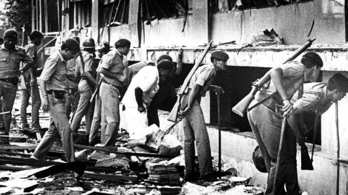Paramilitary officers search for survivors in this March 12, 1993 photo, after a massive explosion ripped through the Bombay Stock Exchange. Twelve bombs exploded on March 12, 1993 in less than 20 minutes at various locations, killing hundreds in India's financial capital. According to the Bombay Police, the prime culprit Dawood Ibrahim, who masterminded the attacks, is still at large and lives as a "free man" in Karachi, Pakistan. (AP Photo/Sherwin Crasto)