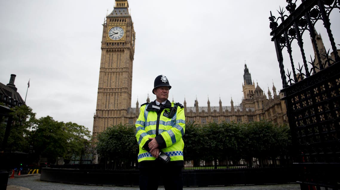 a British police officer stands guard outside the Houses of Parliament in London. The military-style daylight attack on the streets of Paris on Wednesday, Jan. 7, 2015. AP
