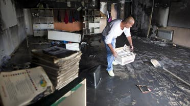 A worker cleans up in a torched classroom in an Arab-Jewish school in Jerusalem, in this November 30, 2014 file picture. An Israeli court jailed two brothers from a far-right Jewish group on July 22, 2015 for the arson attack on the Jerusalem school that had been a rare symbol of co-existence in the riven city. REUTERS/Ronen Zvulun/Files
