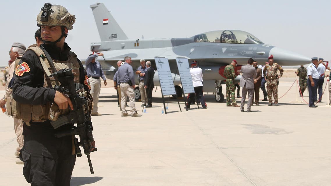 A member of the Iraqi SWAT team stands as security forces and others gather next to one of four new U.S.- made F-16 fighter jets during the delivery ceremony at Balad air base, 75 kilometers (45 miles) north of Baghdad, Iraq, Monday, July 20, 2015. (AP)
