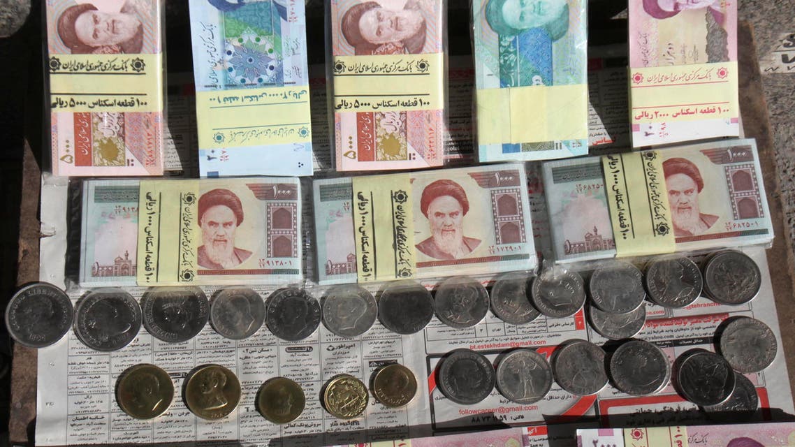 Iranian banknotes and foreign coins are displayed by a vendor on a side walk of the Ferdowsi Street in Tehran, Iran, Wednesday, Jan. 23, 2013. (AP)