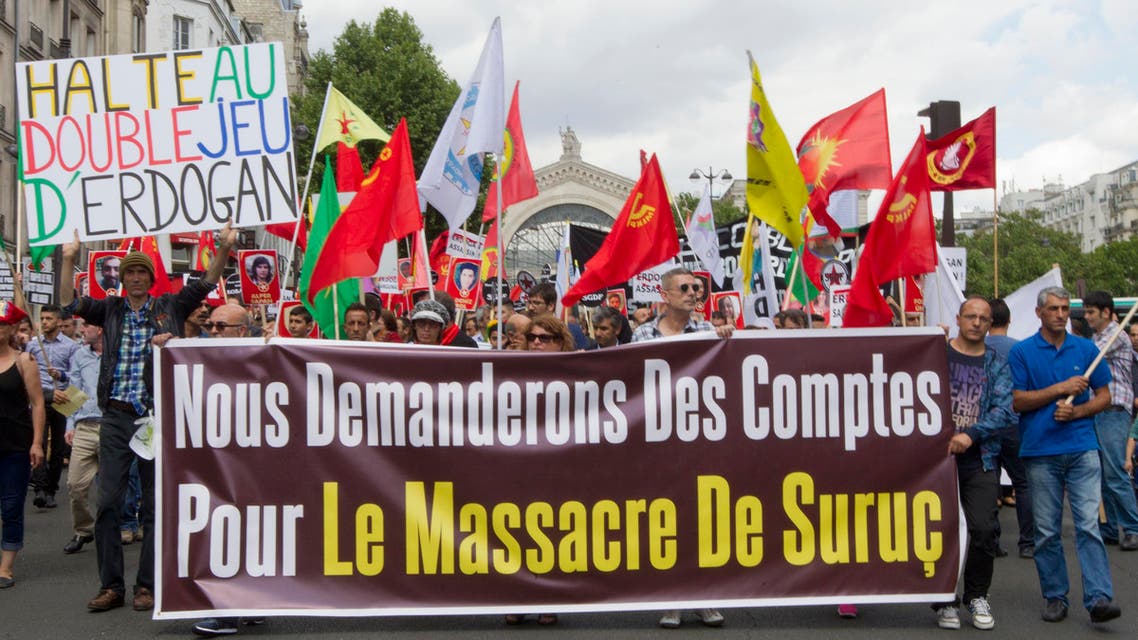  Kurdish demonstrators protest in Paris, France, Saturday, July 25, 2015, denouncing the deaths of 32 people at a suicide bombing Monday, July 20, in Suruc, southeastern Turkey. Turkish warplanes struck Islamic State group targets across the border in Syria early Friday, in a strong tactical shift for Turkey which had long been reluctant to join the U.S.-led coalition against the extremist group. The banner reads: "We demand accountability for the massacre of Suruc" and "Stop the double games of Erdogan." (AP Photo/Jacques Brinon)
