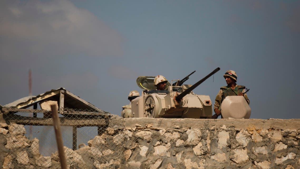 Egyptian army soldiers stand guard on the border with Egypt in Rafah, southern Gaza Strip, Friday, July 5, 2013. Egyptian official said the country's border crossing with Gaza Strip in northern Sinai has been closed indefinitely, citing security concerns. The decision comes hours after suspected Islamic militants attacked four sites in northern Sinai, targeting two military checkpoints, a police station and el-Arish airport, where military aircraft are stationed. (AP Photo/Hatem Moussa)