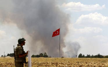 A Turkish soldier stands guard while smoke rises in the Syrian town of Kobane as it is seen from the Turkish border town of Suruc. (File: Reuters)