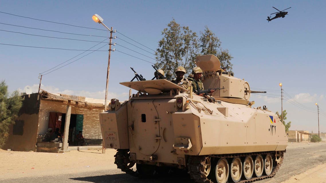 In this Tuesday, May 12, 2013 file photo, Egyptian Army soldiers patrol in an armored vehicle backed by a helicopter gunship during a sweep through villages in Sheikh Zuweyid, north Sinai, Egypt. AP