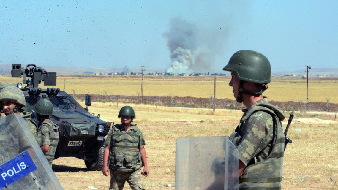 Turkish soldiers stand as smoke billows from the Syrian town of Ayn al-Arab, or Kobani, following the attacks by IS militants as seen from the Turkish side of the border in Suruc, Turkey, Thursday, June 25, 2015. AP