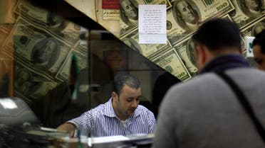 An Egyptian man changes U.S. dollars to Egyptian pounds at a currency exchange office in downtown Cairo, Egypt, Wednesday, Jan. 2, 2013. AP