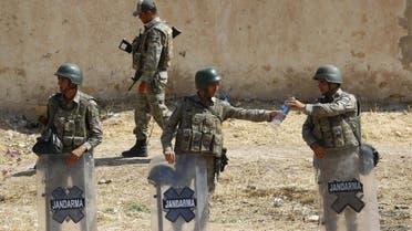 Turkish soldier shares a bottle of water with his comrade as they stand guard near the Mursitpinar border gate in Suruc, bordering with Syrian town of Kobani, Sanliurfa province, Turkey. R 