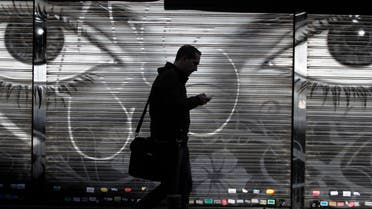 A man looks at his cell phone as he walks on the street in downtown Madrid, Thursday, Oct. 31, 2013. AP