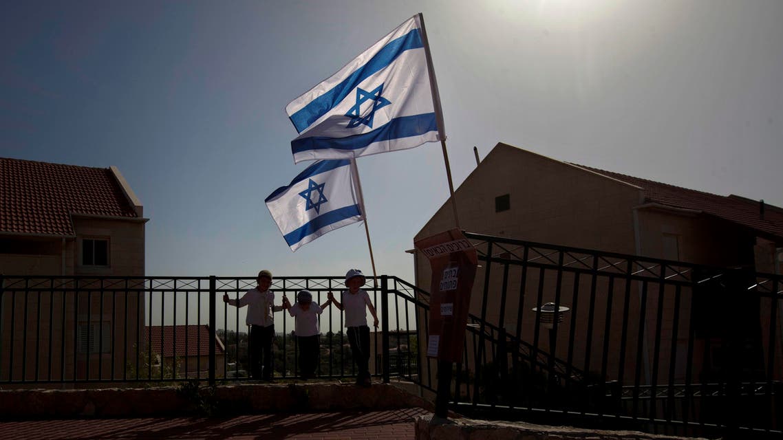 In this Sunday, April 22, 2012 file photo, Israeli flags fly over the Ulpana neighborhood in the West Bank settlement of Beit El near Ramallah. (AP)