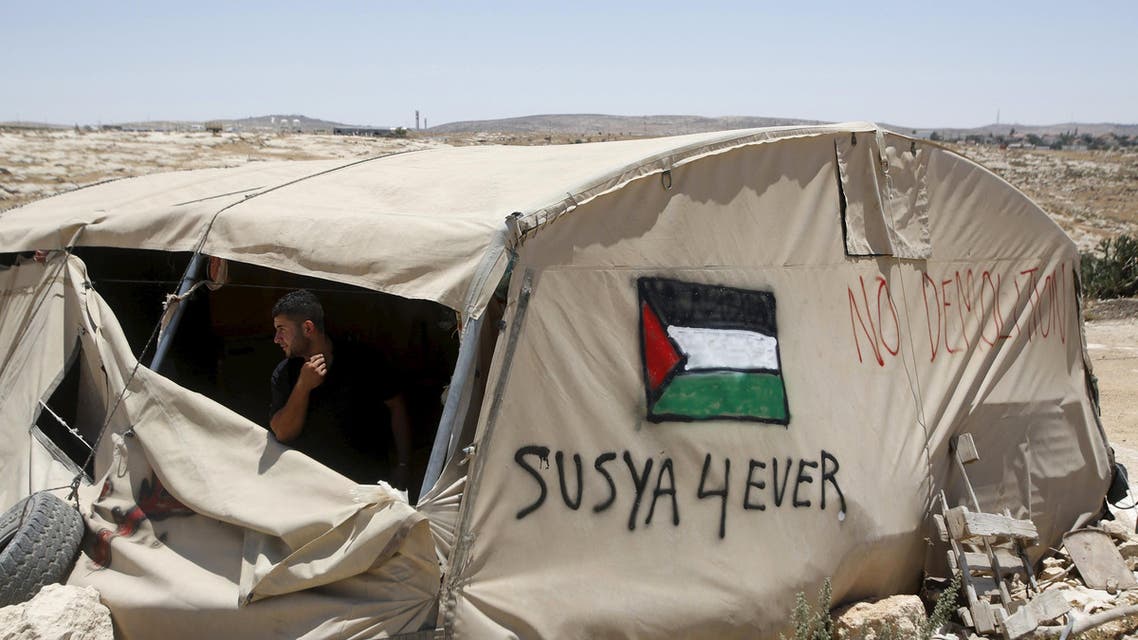 A Palestinian man looks out of a tent in Susiya village, south of the West Bank city of Hebron July 20, 2015. Sitting under a fig tree to escape the searing sun, Jihad Nuwaja looks out on the only land he knows - the dry expanse of the Hebron hills in the southern West Bank. Within days, his home is set to be demolished and he, his wife and 10 children expelled. Nuwaja's family is one of handful living in tents and prefabricated structures at Susiya, a Palestinian village spread across several rocky hillsides between a Jewish settlement to the south and a Jewish archaeological site to the north - land Israel has occupied since the 1967 Middle East war. REUTERS/Mussa Qawasma