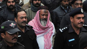 This file photo taken on December 22, 2014 shows Pakistani police escorting the head of banned Lashkar-e-Jhangvi (LeJ) Malik Ishaq (C), as he arrives at the high court in Lahore. AFP