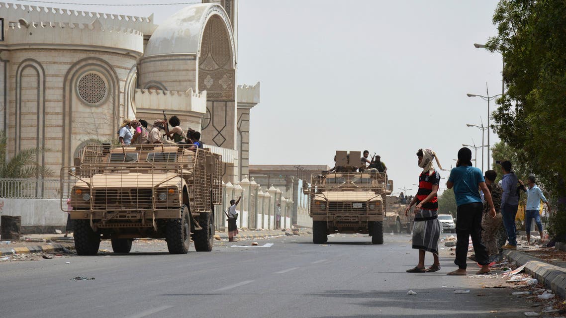 People watch fighters against Shiite rebels as they ride military vehicles on a street in the port city of Aden, Yemen, Tuesday, July 14, 2015. AP