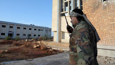 A Libyan military soldier talks on a walkie-talkie outside an empty damaged building in Benghazi. (File: AP)