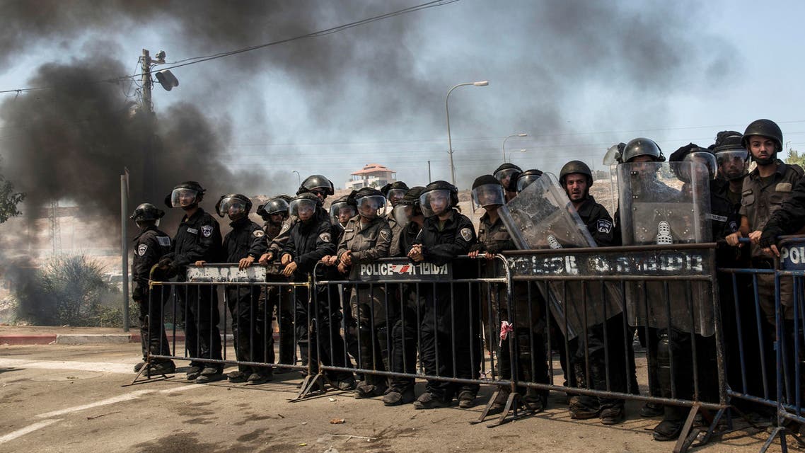 Israeli police stand by with riot gear, during the demolition of a building at the Jewish settlement of Beit El, near the West Bank town of Ramallah, Wednesday, July 29, 2015. (AP)