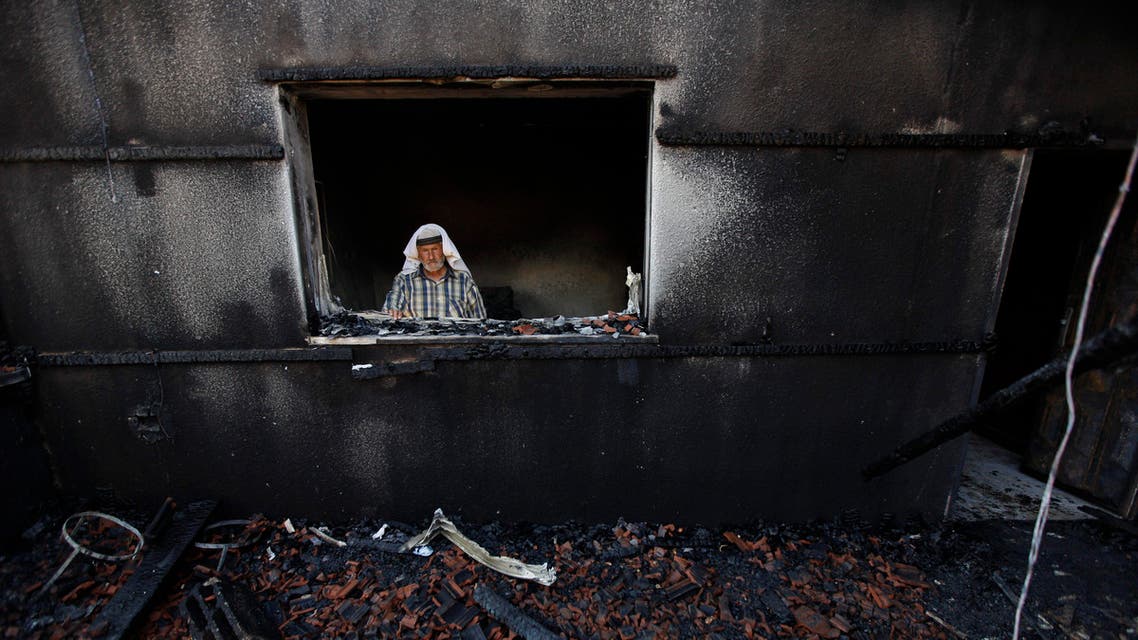 A Palestinian man inspects a house after it was torched in a suspected attack by Jewish settlers killing an 18-month-old Palestinian child. (AP)