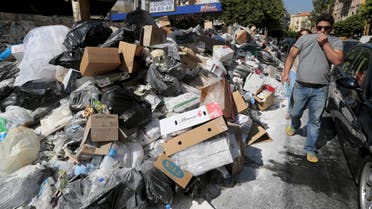 A man covers his nose as he walks past a pile of garbage along a street in Beirut, Lebanon July 22, 2015. (Reuters)