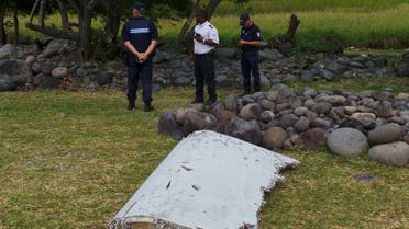 French gendarmes and police stand near a large piece of plane debris which was found on the beach in Saint-Andre, on the French Indian Ocean island of La Reunion. (Reuters)