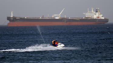 A couple rides a jetski past the Egyptian crude oil tanker "Sharifa 4" near the beach in El Ain El Sokhna port in Suez before the tanker enters the Suez Canal, east of Cairo, Egypt, July 26, 2015. The first cargo ships passed through Egypt's New Suez Canal on Saturday in a test-run before it opens next month, state media reported, 11 months after the army began constructing the $8 billion canal alongside the existing 145-year-old Suez Canal. REUTERS/Amr Abdallah Dalsh