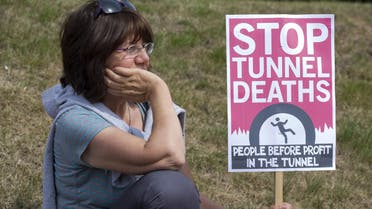 protester waits with a placard outside an entrance to the Eurotunnel terminal in Folkestone, south east England, on August 1, 2015