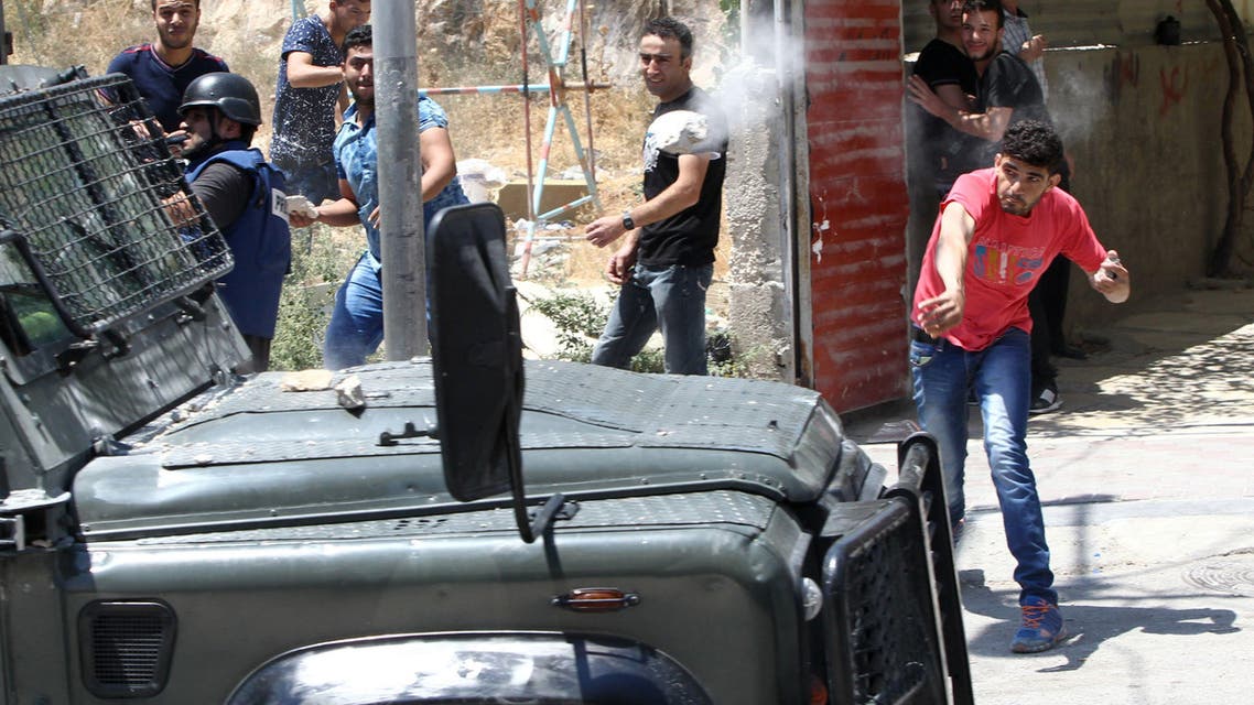 A Palestinian throws a stone towards a vehicle of Israeli security forces during clashes following a demonstration of Islamist Hamas supporters in support of Jerusalem's Al-Aqsa mosque on July 31, 2015 AFP