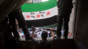 In this Friday, Sept. 21, 2012 file photo, Free Syrian Army rebels hold a revolutionary flag during a demonstration in the Bustan al-Qasr neighborhood of Aleppo, Syria. AP