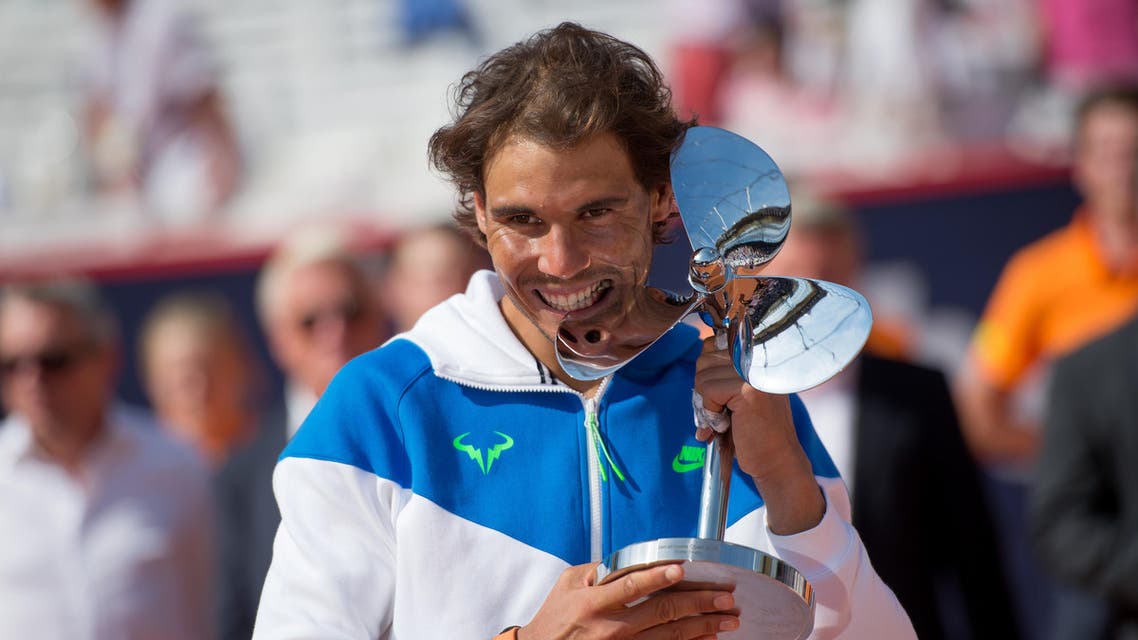 Spain's Rafael Nadal celebrates with the trophy after he won the final match of the Hamburg Open ATP tennis tournament against Fabio Fognini of Italy, in Hamburg, Germany, Sunday Aug. 2, 2015. AP