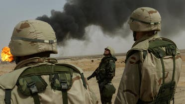 US soldiers patrol near the burning North Ramala oil fields, in southern Iraq, on March 27, 2003. Photo: AP