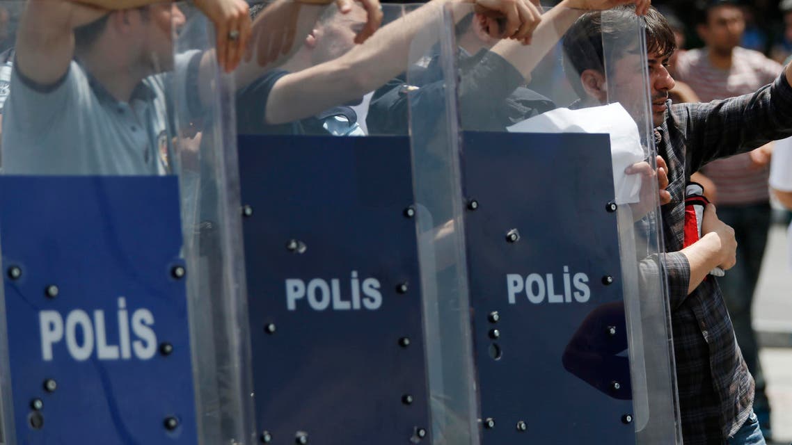 A tourist tries to get information from police that blocked Taksim square in Istanbul, Turkey, to demonstrators trying to reach the adjacent Gezi Park marking the second anniversary of the start of 2013 nationwide anti-government protests, Sunday, May 30, 2015. Thousands of protests were sparked two years ago by opposition to government plans to uproot trees at Gezi Park and to build a shopping center. (AP Photo/Lefteris Pitarakis)