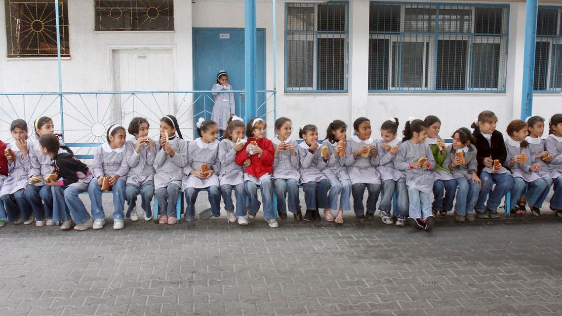 Palestinian school girls eat sandwiches provided by the United Nations, at a UN elementary school at Shati refugee camp in Gaza City, Thursday, Nov. 20, 2008. Israel's tightening Gaza blockade, a response to Palestinian militant rocket fire, has led to frequent blackouts throughout Gaza and resulted in shortages of food, supplies and even cash.(AP Photo/Adel Hana)