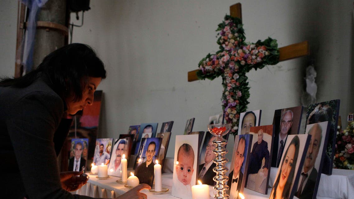 A woman lights a candle among pictures of slain Iraqi Christians at Our Lady of Salvation church in Baghdad, Iraq, Friday, Dec. 31, 2010. Militants in Iraq have attacked at least four Christian homes with a combination of grenades and bombs, killing and wounding a few people and sending fear into the country's already terrified tiny Christian community, police said. (AP Photo/Khalid Mohammed)