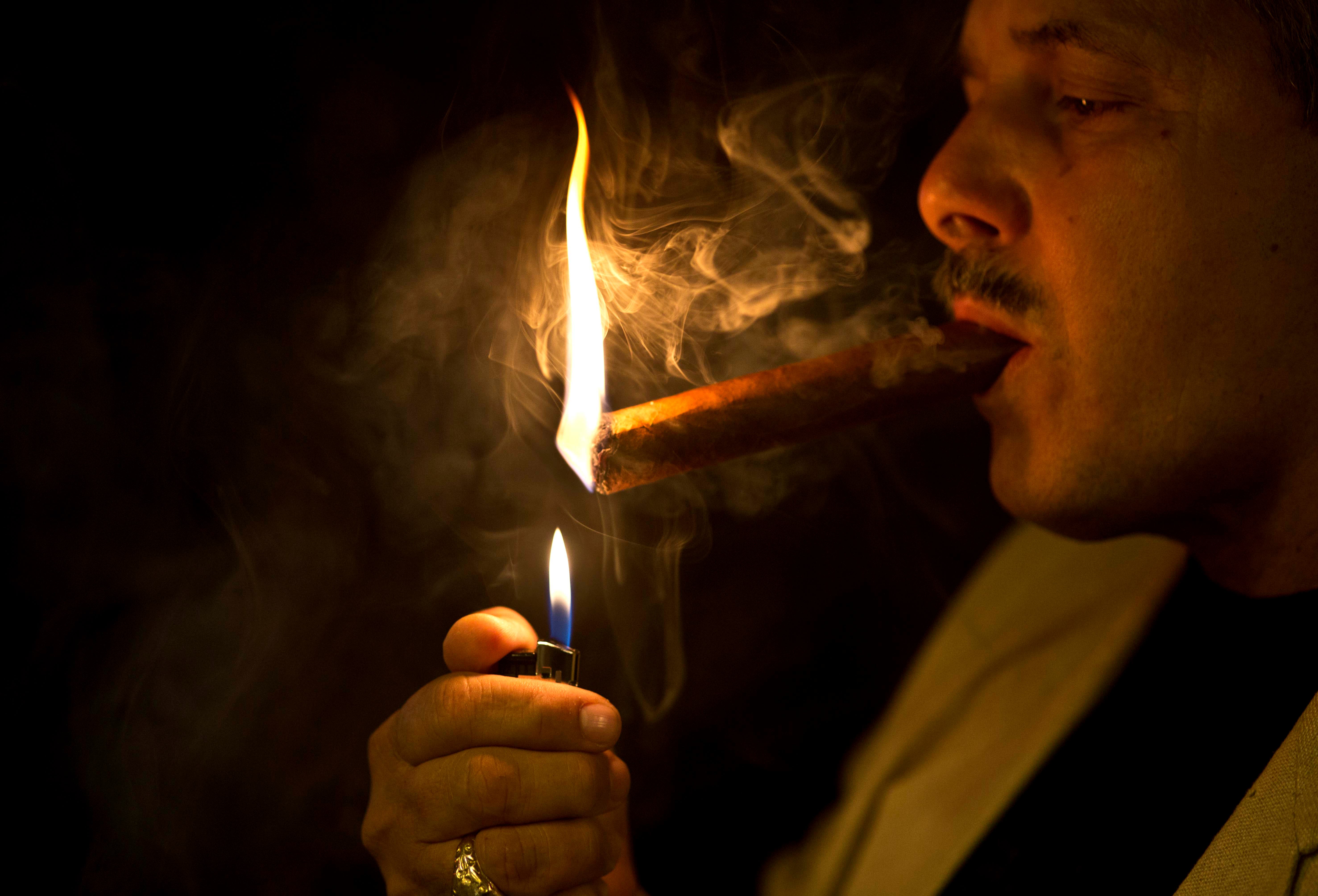 A man lights a cigar in a cigar club shop in Havana, Cuba, Friday, Dec. 19, 2014. (AP)