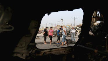 Civilians, seen through wreckage, inspect the aftermath of a car bomb explosion in the Shiite predominant district of Sadr city, Baghdad, Iraq, Thursday, Aug. 6, 2015. AP 