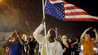 Protesters march in the rain, Sunday, Aug. 9, 2015, in Ferguson, Mo. Sunday marks one year since Michael Brown was shot and killed by Ferguson Police Officer Darren Wilson. (AP)