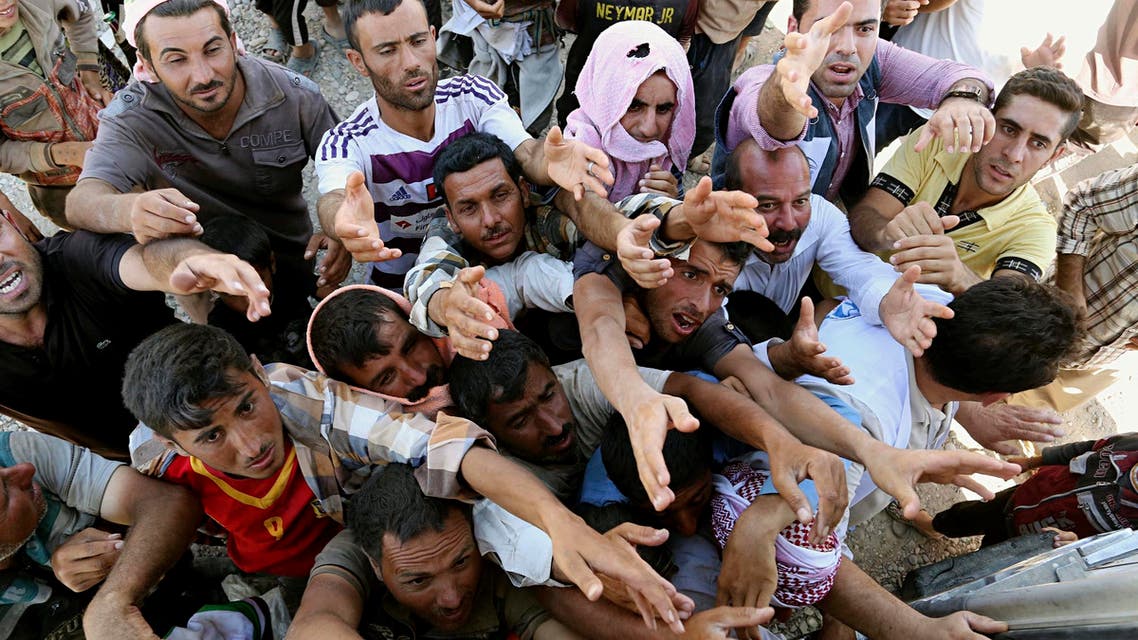Displaced Iraqis from the Yazidi community gather for humanitarian aid at the Syria-Iraq border at Feeshkhabour border point, northern Iraq. (AP)