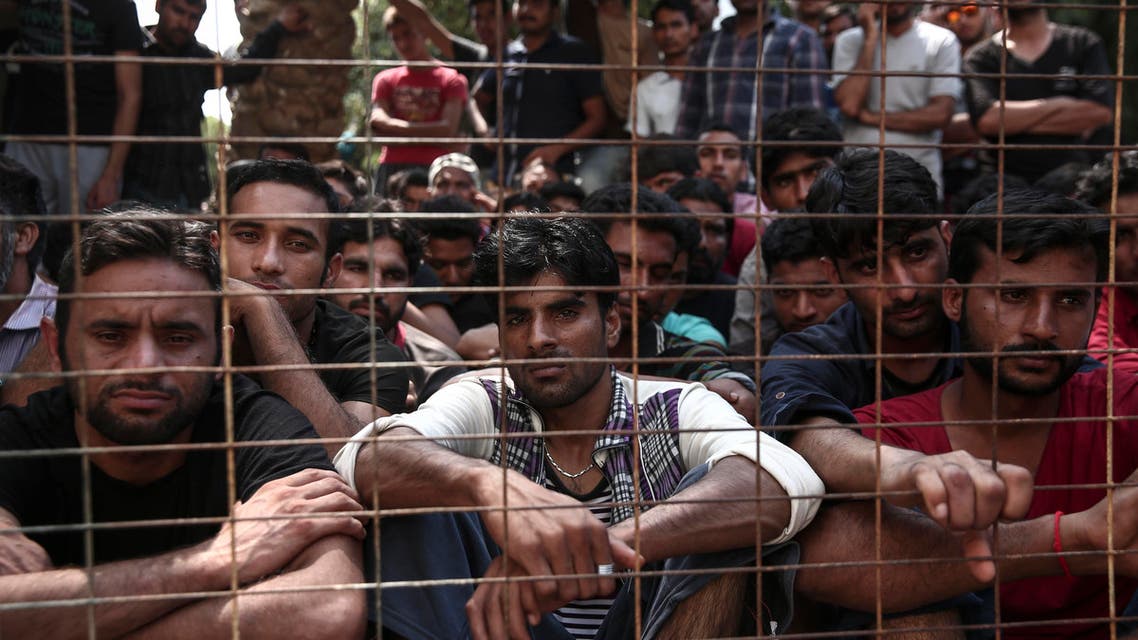 Migrants wait behind a fence for a registration procedure outside a police station at southeastern island of Kos, Monday, Aug. 10, 2015. AP 