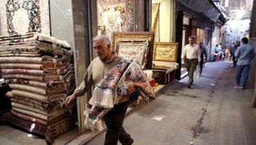 An Iranian man carries a carpet through Tehran's old, main bazaar, Iran. (AP)