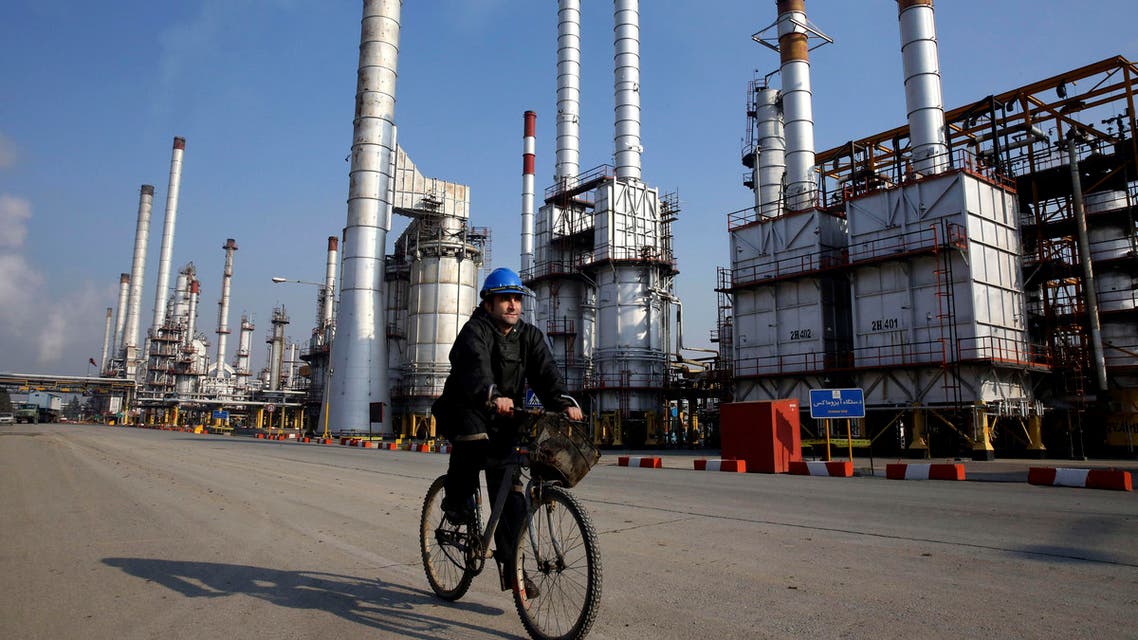 In this Monday, Dec. 22, 2014 photo, an Iranian oil worker rides his bicycle at the Tehran's oil refinery south of the capital Tehran, Iran. (AP)
