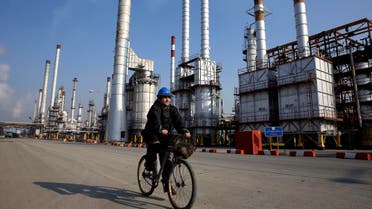 In this Monday, Dec. 22, 2014 photo, an Iranian oil worker rides his bicycle at the Tehran's oil refinery south of the capital Tehran, Iran.  (AP)