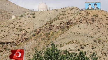   Supreme leaders of Iran, the late Ayatollah Ruhollah Khomeini (L) and Ayatollah Ali Khameni (R), are seen on the top of a hill from the Turkish side of the border near the Esendere crossing between Turkey and Iran on June 25, 2012 in Yuksekova (AFP Photo/Bulent Kilic)