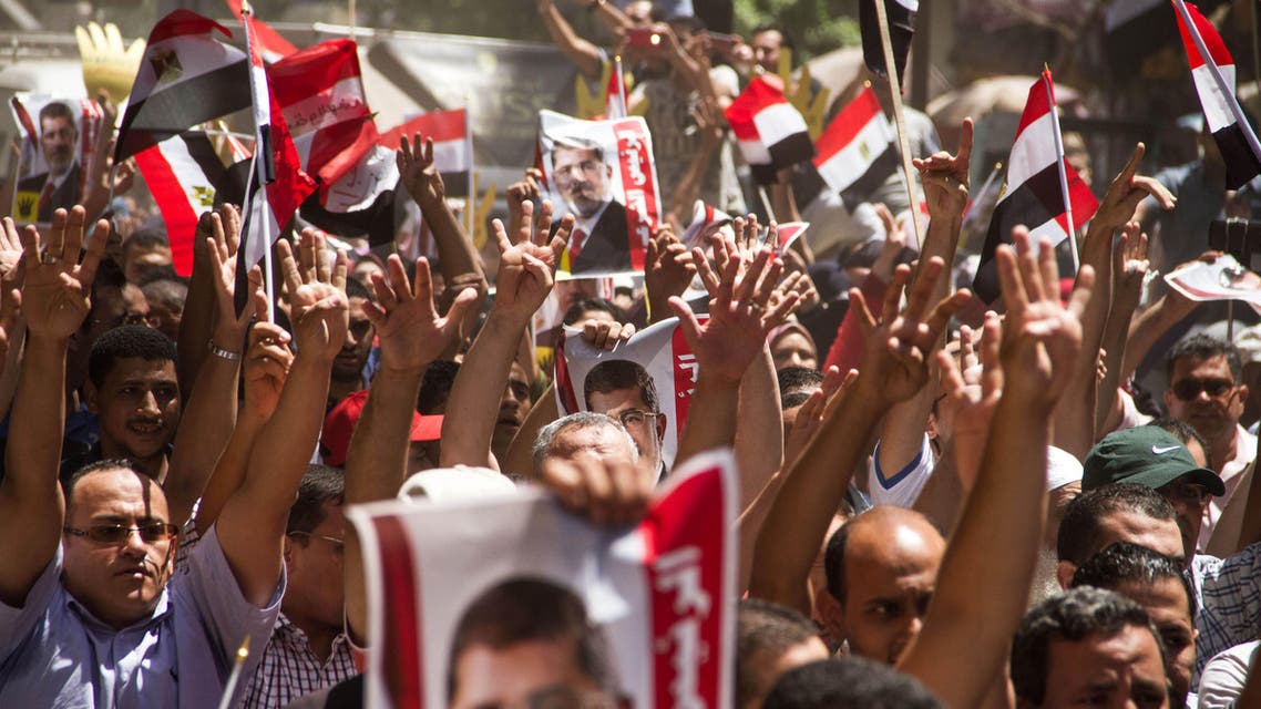 Members of the Muslim Brotherhood hold up pictures of their ousted President Mohammed Morsi during a protest two years after hundreds were killed in a single day when Egyptian troops moved in to disperse sit-ins by Islamist supporters of the Brotherhood, in the Talbia district of Giza, Egypt, Friday, Aug. 14, 2015.