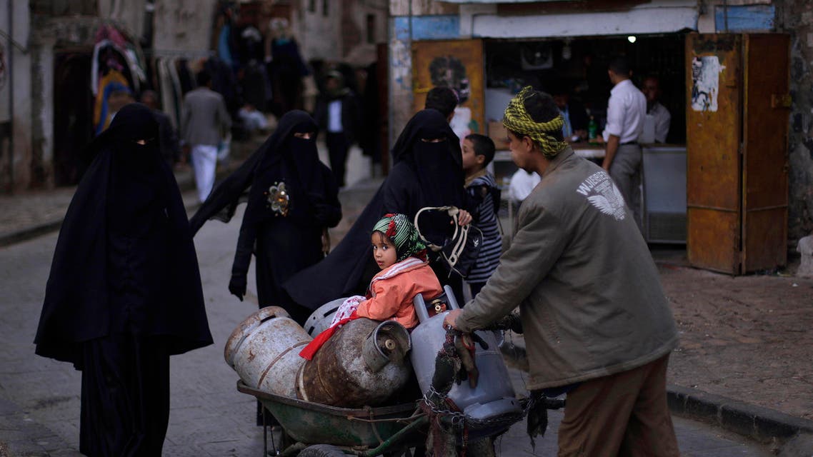 FILE - In this Monday, Nov. 22, 2010 file photo, photo a young Yemeni girl sitting over cooking gas canisters loaded in a cart pushed by her father, looks back, in the old city of Sanaa, Yemen. Almost two months of unrest in Yemen has more than doubled the price of some basic foodstuffs and cooking gas while the value of the rial has plummeted, deepening the strain in what was already the Arab world's poorest nation.(AP Photo/Muhammed Muheisen, File)