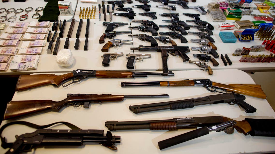  Weapons that were seized during an anti-drug raid, are displayed on a table for a media presentation in Buenos Aires, Argentina, Friday, May 16, 2014. The Argentine government on Friday announced the dismantling of a band of transnational drug traffickers who transported liquid cocaine from Argentina to Mexico with the intention of diverting to Europe and the United States. Weapons, computers and banknotes that were seized in the anti-drug operation were presented during a press conference. (AP Photo/Natacha Pisarenko)