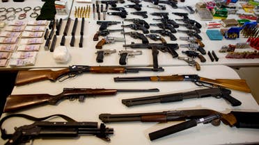  Weapons that were seized during an anti-drug raid, are displayed on a table for a media presentation in Buenos Aires, Argentina, Friday, May 16, 2014. The Argentine government on Friday announced the dismantling of a band of transnational drug traffickers who transported liquid cocaine from Argentina to Mexico with the intention of diverting to Europe and the United States. Weapons, computers and banknotes that were seized in the anti-drug operation were presented during a press conference. (AP Photo/Natacha Pisarenko)