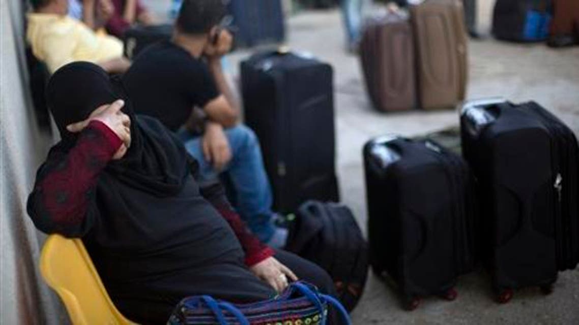 A Palestinian woman rests as she waits to cross the border into Egypt, at the Rafah crossing in the southern Gaza Strip, Monday, Aug 17, 2015. (AP)