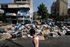 A Lebanese man passes a pile of garbage blocking a street in east Beirut, Lebanon, Monday, Aug. 17, 2015. AP 