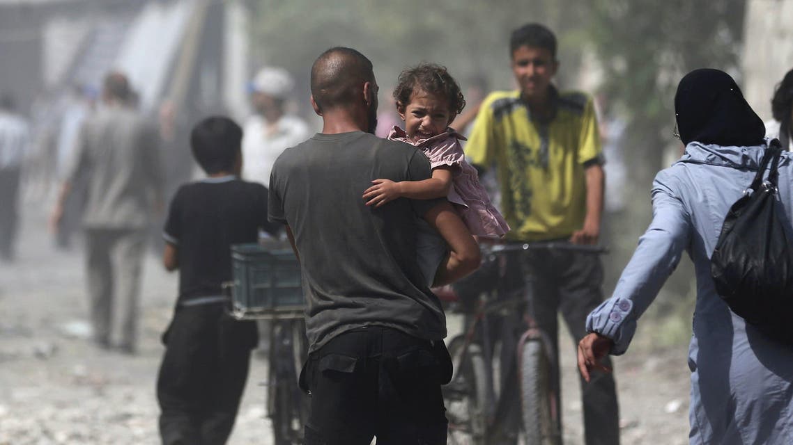 Man carries a girl reacting at a site hit by what activists said were air strikes by forces loyal to Syria's President Bashar al-Assad on a marketplace in the Douma neighborhood of Damascus, Syria Reuters