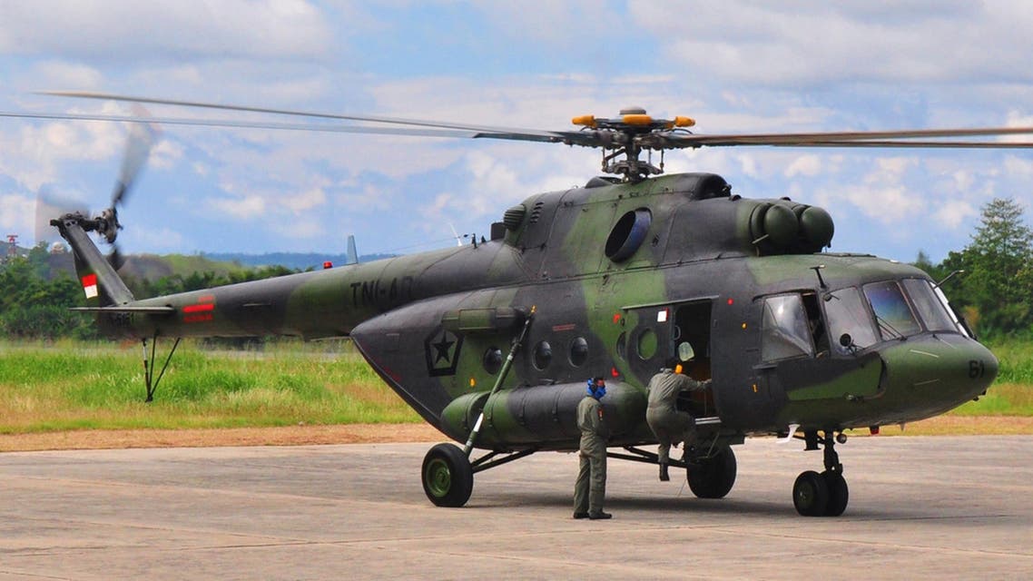 Indonesian air force personnel prepare a military helicopter at Sentani airport in Jayapura on August 18, 2015 in preparation for the search operation