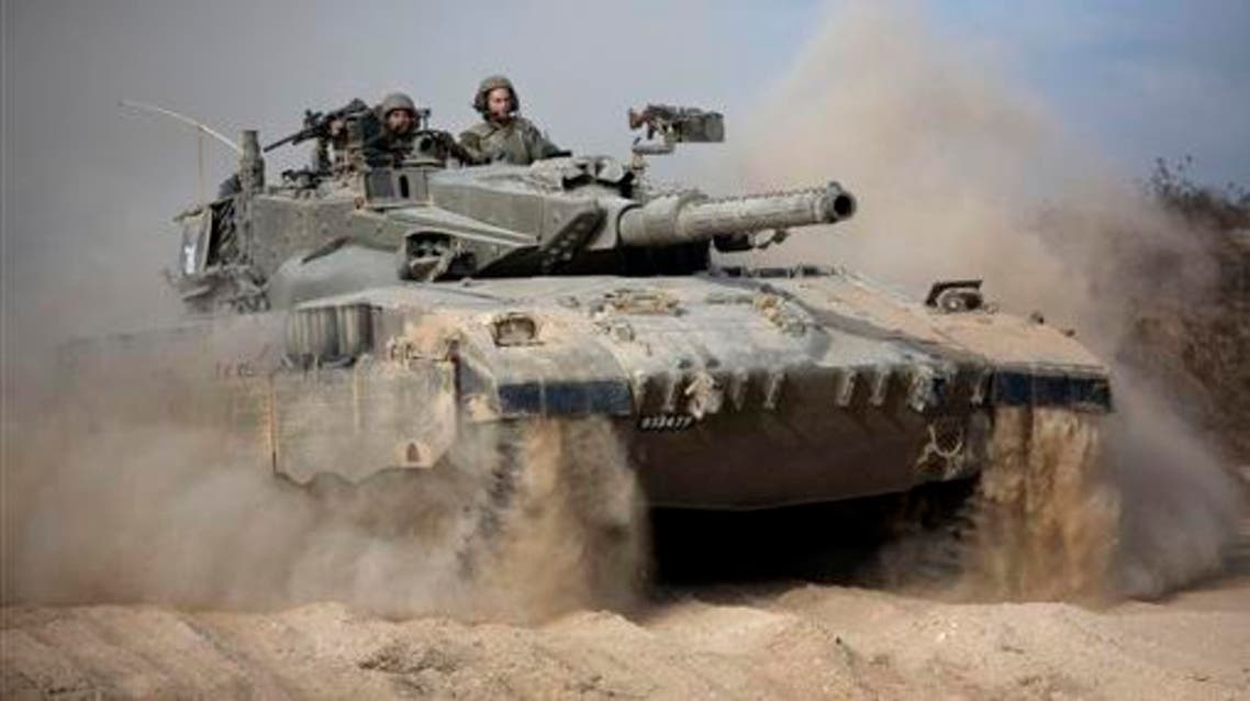 In this Friday, July 18, 2014 file photo, an Israeli tank moves into position near Israel and Gaza border. A fierce debate is raging within Israel's military over the extent to which soldiers should be held legally accountable for their actions during last year's Gaza war, with commanders increasingly at odds with military lawyers.(AP Photo/Dusan Vranic, File)