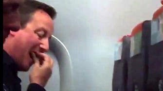 High flyer? Maybe not. Cameron spotted squashed in to economy seat